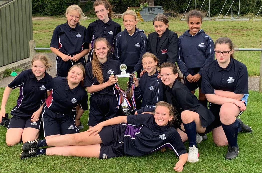 A group of girls holding a trophy for Tag Rugby