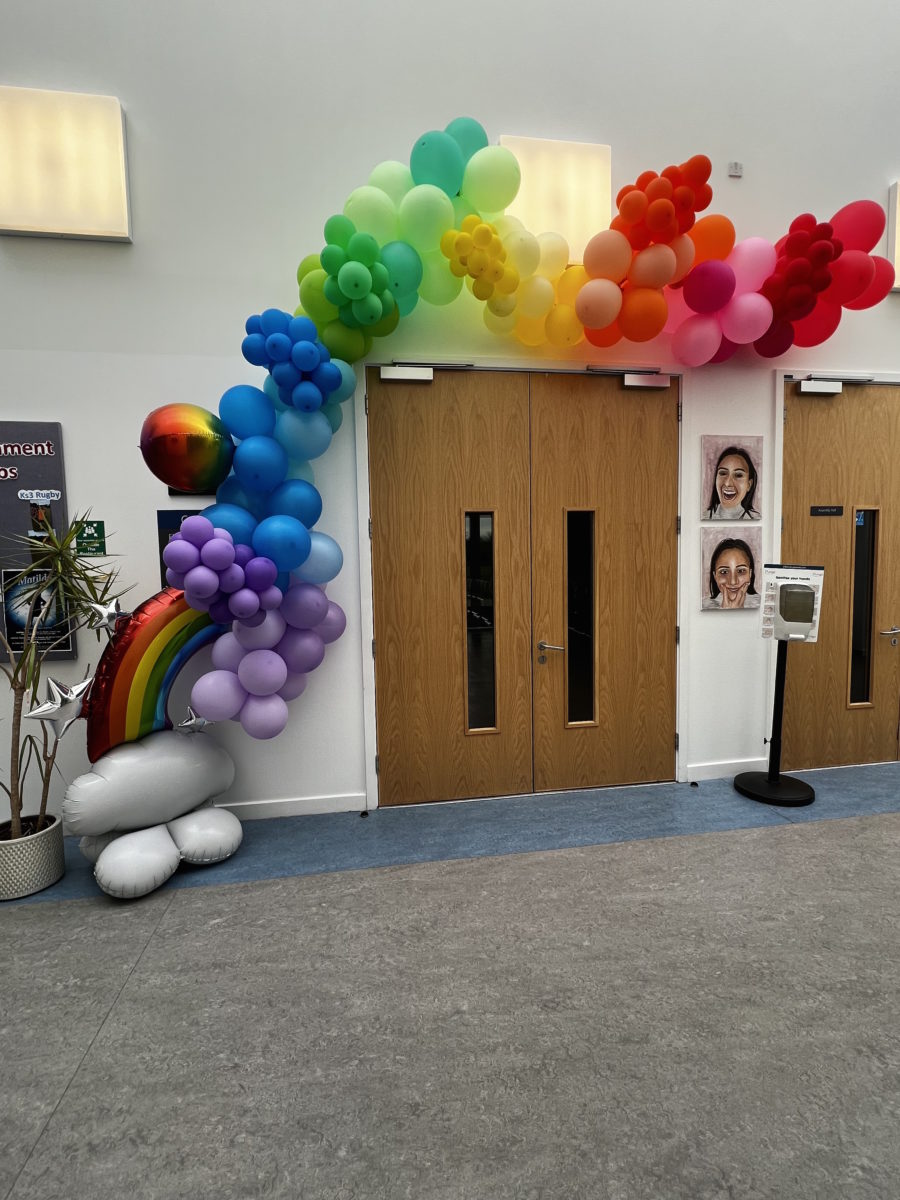 Rainbow balloon archway above a door frame
