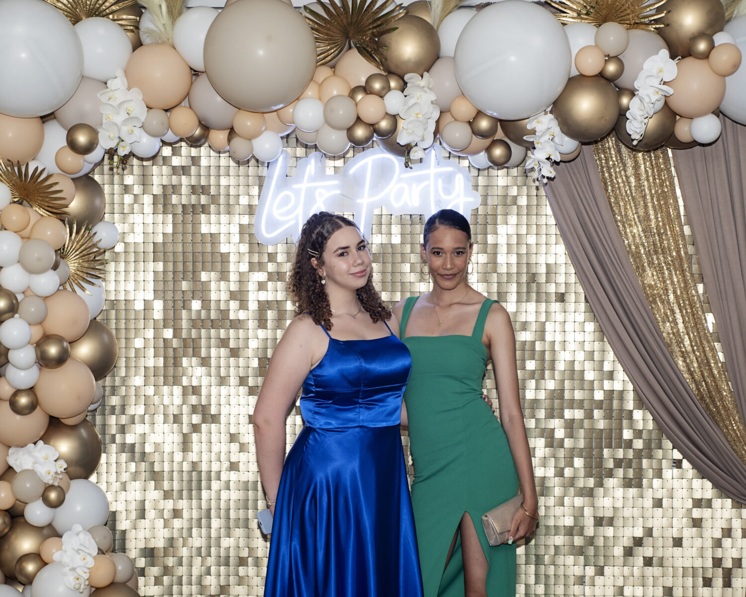Two students in front of a backdrop posing during their Year 11 prom