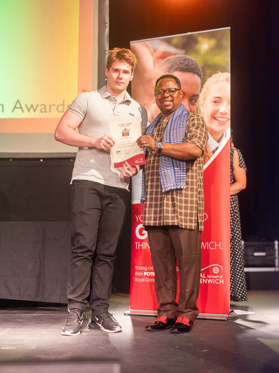Connor, an ex Year 13 student stood with his award certificate and a prize giver