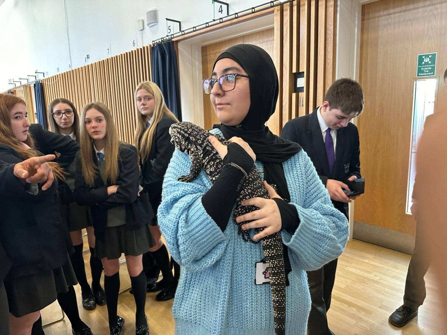 Student holding a lizard over their shoulder